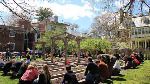 HDS community members gathered in a circle around a community garden